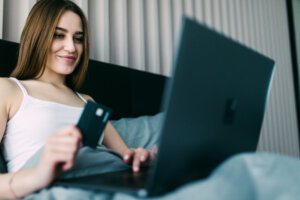 Cómo evitar fraudes al comprar en línea con seguridad 3 beautiful young woman using her credit card web shopping lying bed